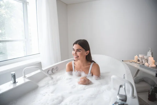Оптимистичная девушка, отдыхающая в уютной ванне — стоковое фото