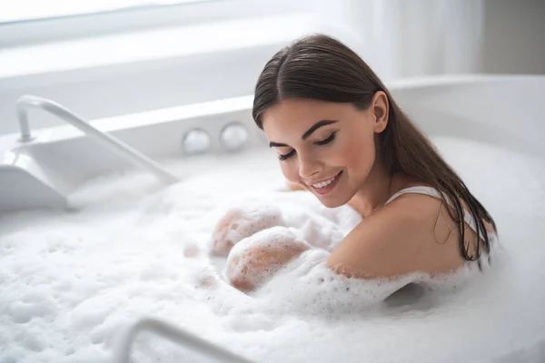 Alegre hembra tener ocio en acogedor baño — Foto de Stock