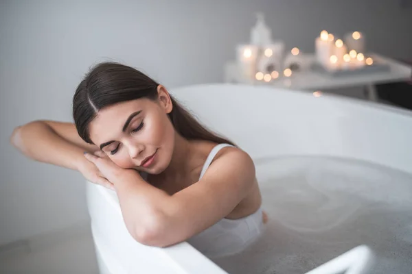 Ragazza ordinata sdraiata in acqua durante il trattamento — Foto Stock