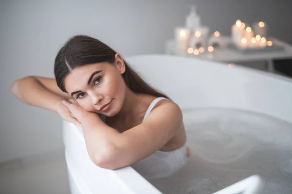 Dama pensativa apoyada en el baño durante el procedimiento —  Fotos de Stock