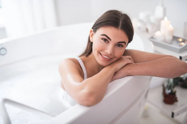 Alegre mujer relajándose en el agua en el apartamento —  Fotos de Stock