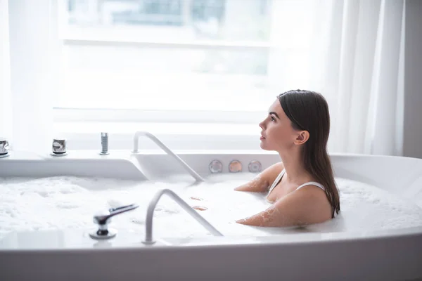 Nachdenkliche Frau mit Muße im warmen Wasser — Stockfoto