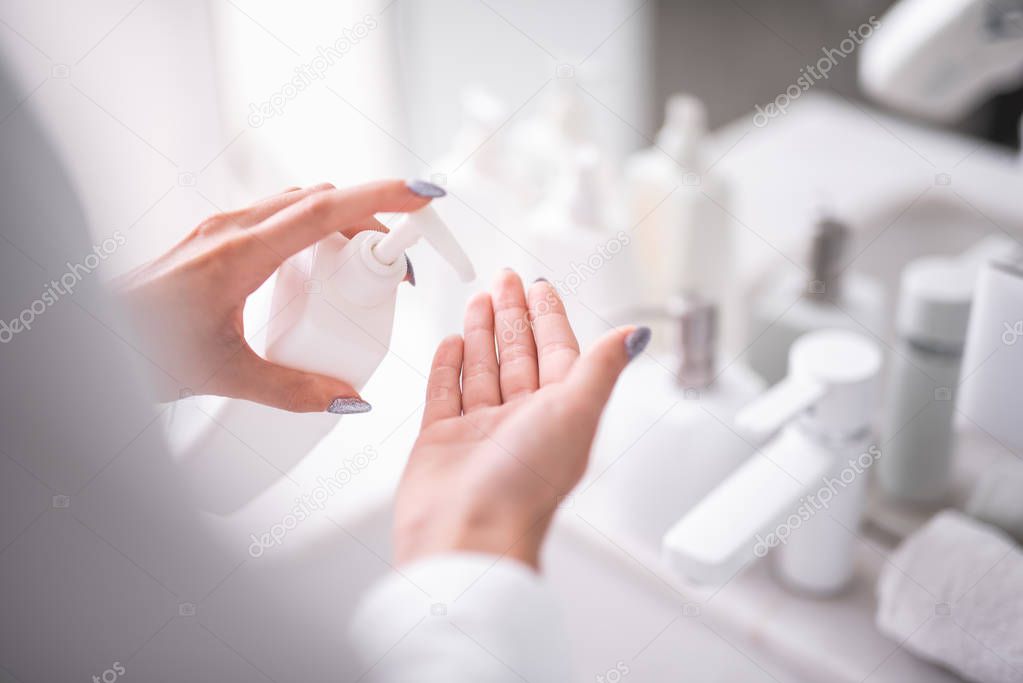 Woman keeping liquid detergent for cleaning arms
