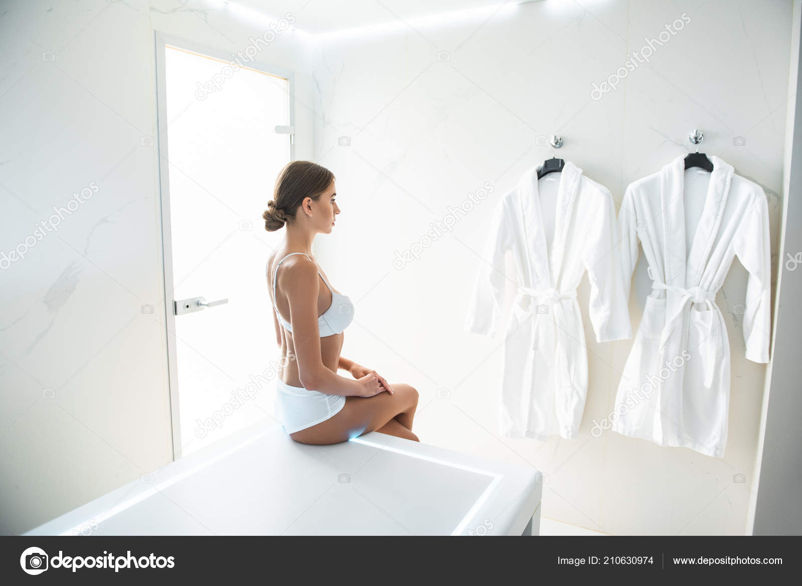 肌触りのよいバスローブを見て壁に白いランジェリーの魅力的な若い女性 ストック写真 C Iakovenko123 肌触りのよいバスローブを見て壁に白いランジェリーの魅力的な若い女性 ストック写真 C Iakovenko123