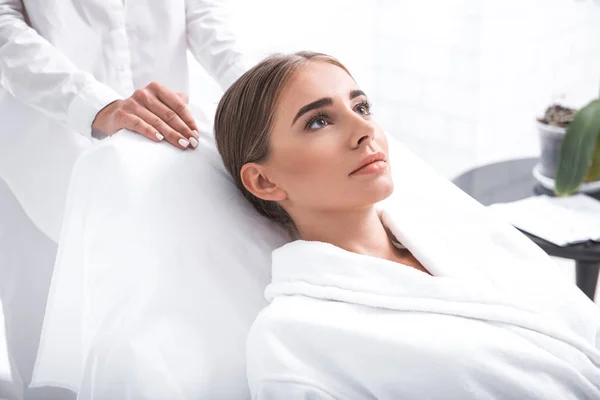 Usměvavá mladá žena ležící na válendu v beauty salonu — Stock fotografie