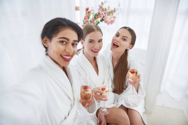 Spa salon de poz alkollü içecekler ile neşeli kızlar