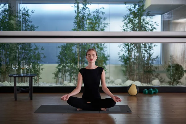 Mat lotus poz oturan genç bayan