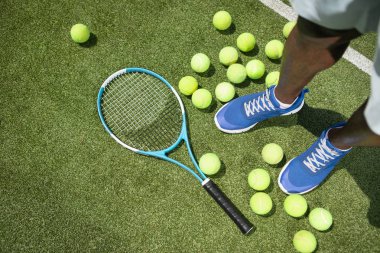 Adam tenis malzemeleri kullanarak
