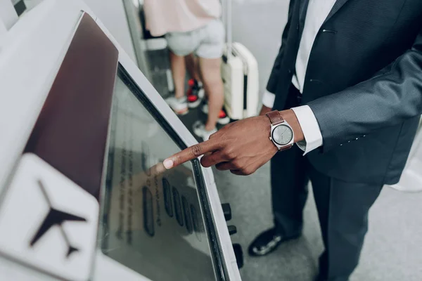Взрослый человек пользуется банкоматом в аэропорту — стоковое фото