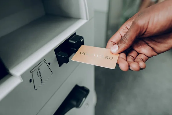 Человек вытаскивает банковскую золотую карту в банкомат — стоковое фото
