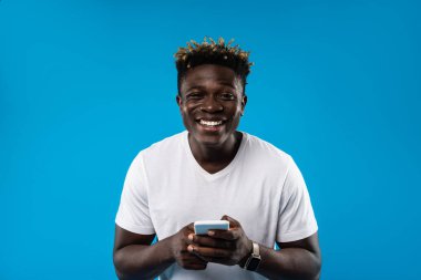 Neşeli adam beyaz smartphone tutan dreadlocks ile