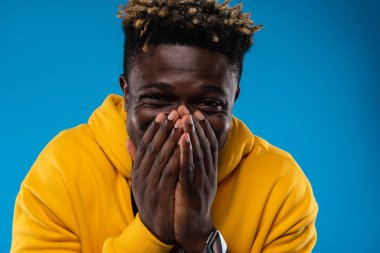 Neşeli adam yüz el ile koruyor