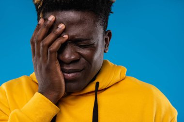 Üzgün adam yüzünü eli ile sol tarafını koruyor