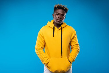 Yakışıklı olan mavi arka plan üzerinde poz