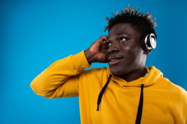 Yakışıklı olan mavi arka plan üzerinde müzik keyfi