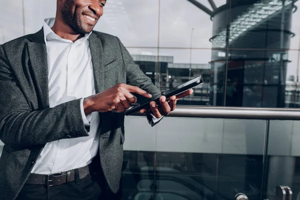 Cara positivo está usando tablet pc fora do terminal — Fotografia de Stock