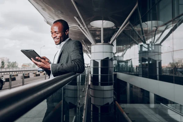 Уверенный бизнесмен пользуется планшетом под открытым небом — стоковое фото