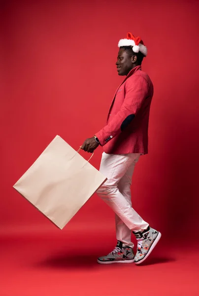 Улыбающийся парень держит белый бумажный пакет — стоковое фото