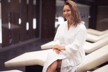 Büyüleyici orta yaşlı beyaz bornoz rahatlatıcı spa salonunda kadın