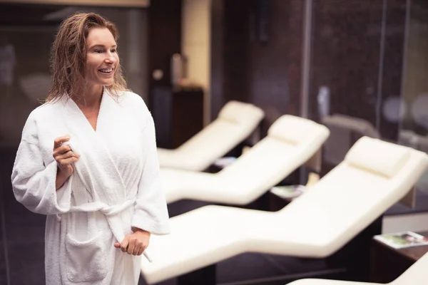 Mooie midden leeftijd vrouw koppelverkoop badjas riem en glimlachen — Stockfoto