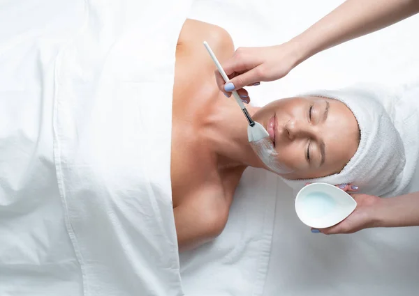 Kosmetička ruka použití masku na tváři paní pomocí speciální štětce — Stock fotografie
