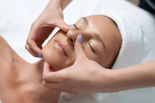 Attraente signora di mezza età che riceve massaggio facciale al salone spa — Foto Stock