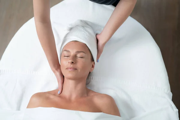 Sonriente señora de mediana edad disfrutando de masaje en el cuello en el salón de spa —  Fotos de Stock