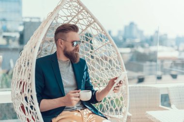 Telefon kullanarak ve sıvı tatma sakin erkek