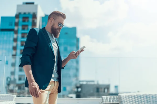 Ordnad mannen skickar meddelande i telefonen utanför — Stockfoto