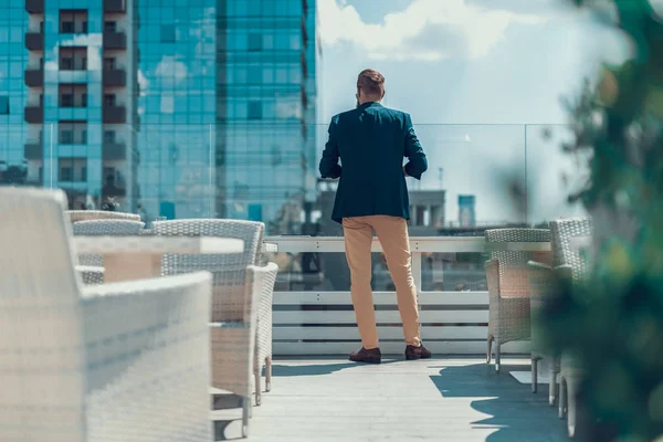 Hombre mirando a la calle desde el balcón exterior — Foto de Stock