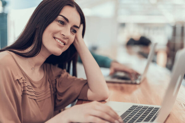 Smiling female using notebook computer during job