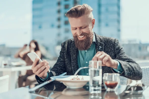 Hombre satisfecho comiendo deliciosa cocina en el restaurante — Foto de Stock