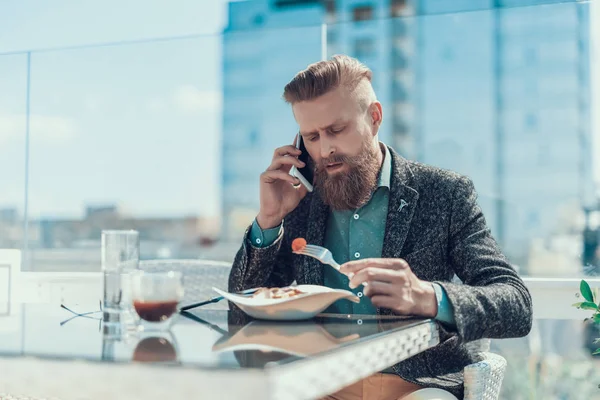 Спокойный человек разговаривает по телефону во время ужина — стоковое фото
