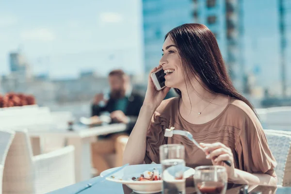 Utgående kvinna berättar på telefonen i restaurang — Stockfoto