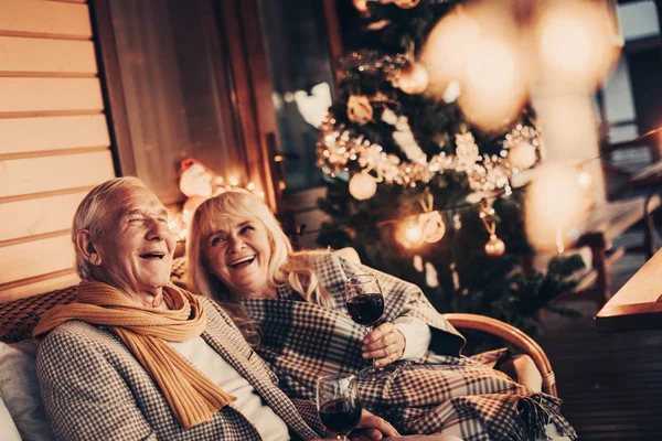 Зрелые улыбающиеся двое, празднующие Рождество со смехом — стоковое фото