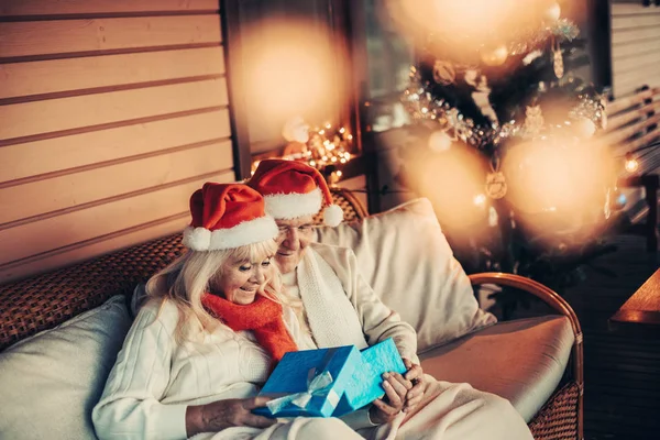Radostné starších dvojka pohlédl na vánoční dárek — Stock fotografie
