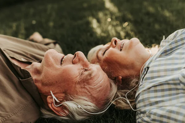 Zijaanzicht van ouder paar oortelefoons met — Stockfoto