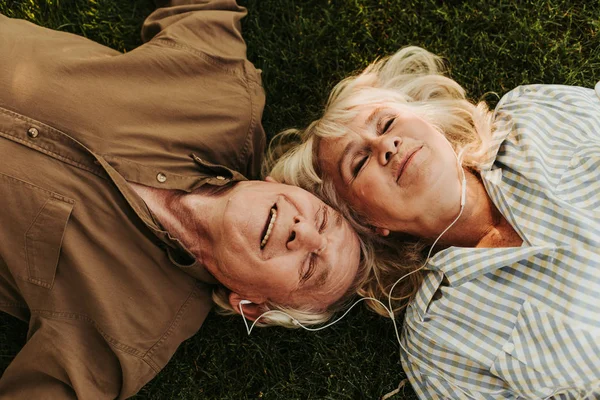 Fröhliche Senioren zu zweit genießen Musik im Freien mit Lächeln — Stockfoto
