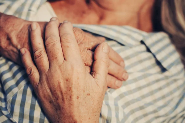 Hombre maduro sosteniendo el brazo de una mujer anciana — Foto de Stock