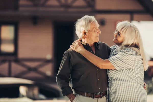 Selbstbewusstes älteres Ehepaar steht vor Haus — Stockfoto