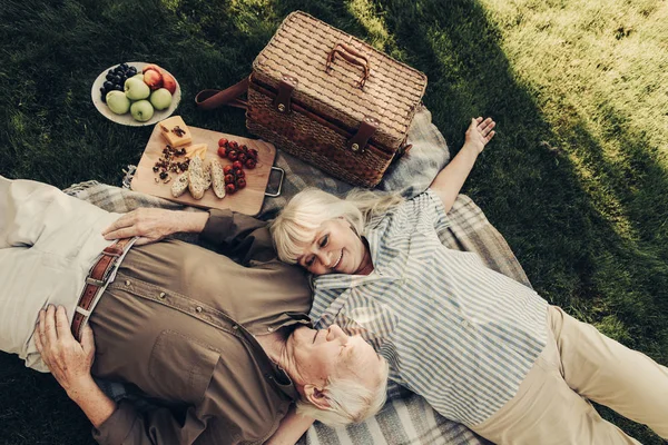 Alegre pareja de ancianos relajarse en cuadros al aire libre — Foto de Stock