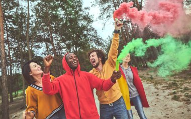 Pembe ve yeşil duman mum tutan adamlar