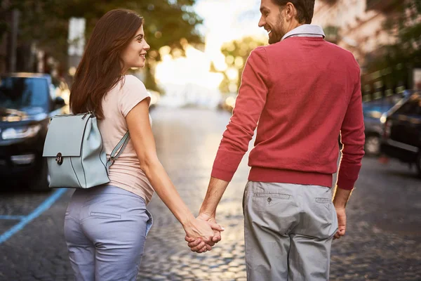 愛するカップルが歩きながら手を繋いで道をおろす — ストック写真