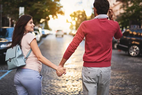 Jovens pais expectantes de mãos dadas enquanto caminham pela rua — Fotografia de Stock