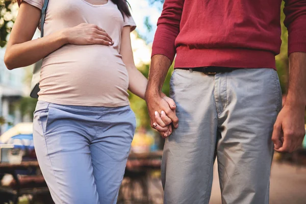 Lyckliga nyblivna föräldrar hålla händerna på suddig bakgrund — Stockfoto