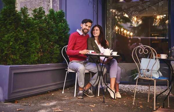 Vackra älskande par som sitter vid bordet på uteserveringen — Stockfoto