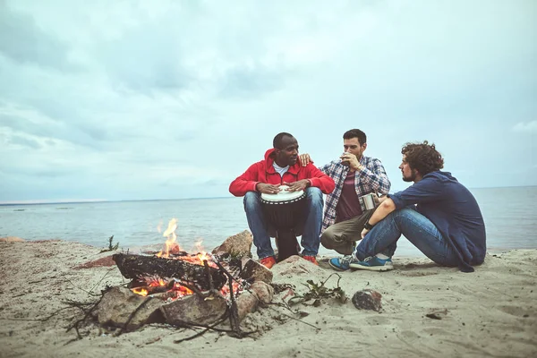 Positieve man is zittend en djembe spelen — Stockfoto