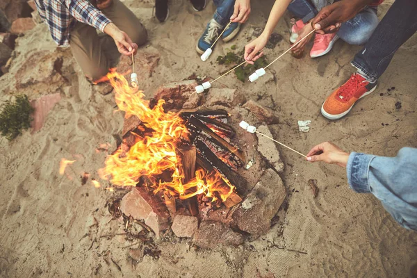 Группа людей, готовящих жареные зефир в огне — стоковое фото