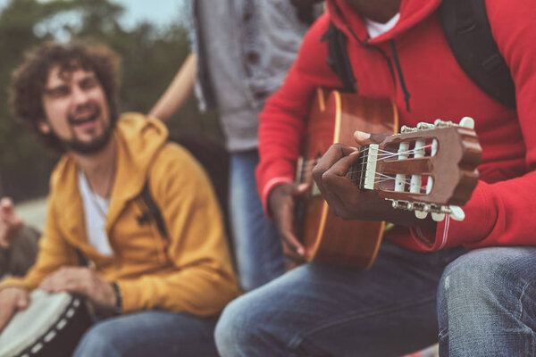 Happy man playing while his friend accompanying on djembe