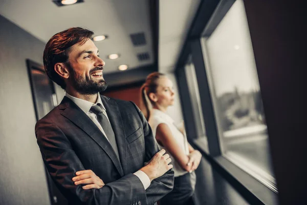 Pleased unshaven male watching at window inside — Stock Photo, Image